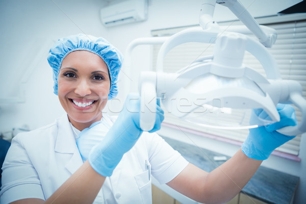 Smiling female dentist adjusting light Stock photo © wavebreak_media
