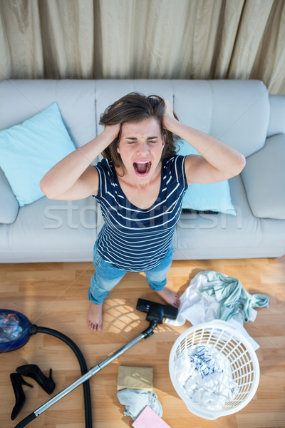 Angry woman in a chaotic living room with vacuum cleaner Stock photo © wavebreak_media