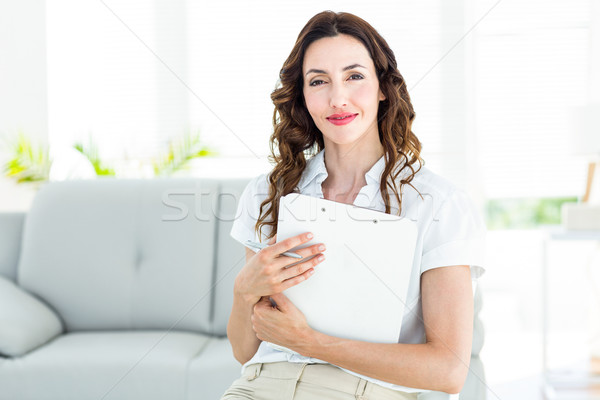 Smiling therapist holding her clipboard Stock photo © wavebreak_media