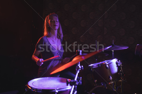 Stock photo: Confident female drummer performing in nightclub