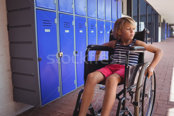 Thoughtful student sitting on wheelchair in corridor Stock photo © wavebreak_media