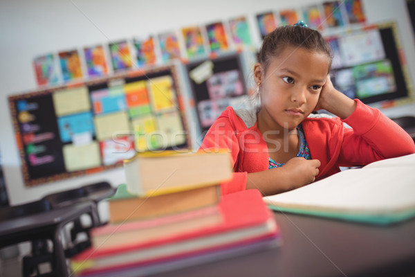 Stock photo: Thoughtful schoolgirl sitting at desk