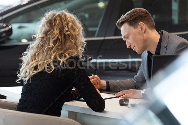 Car salesperson talking with customer in showroom Stock photo © wavebreak_media