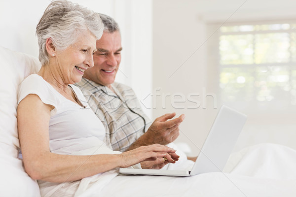 Pareja de ancianos usando la computadora portátil cama sesión mujer hombre Foto stock © wavebreak_media