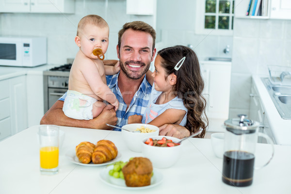 Sorridente homem dois crianças café da manhã cozinha Foto stock © wavebreak_media