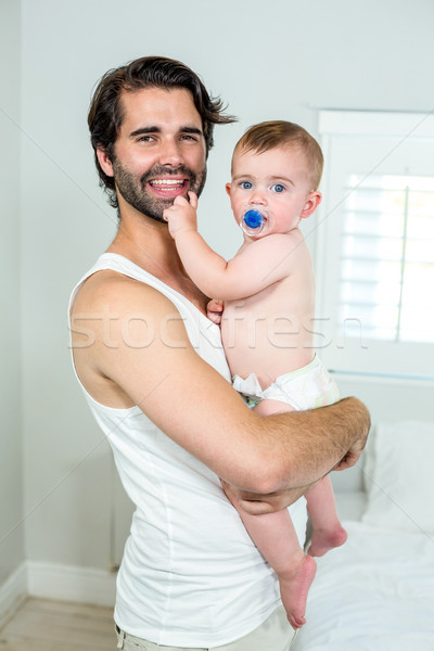 Happy father carrying baby son by bed at home Stock photo © wavebreak_media