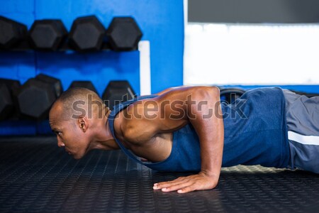 Stock photo: Man exercising with tire in gym