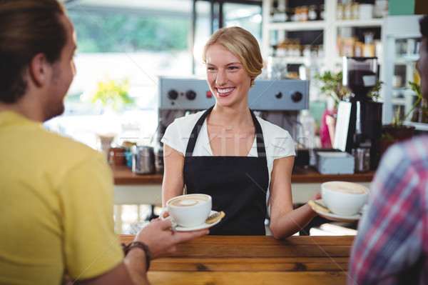 Uśmiechnięty kelnerka kubek kawy klienta Zdjęcia stock © wavebreak_media