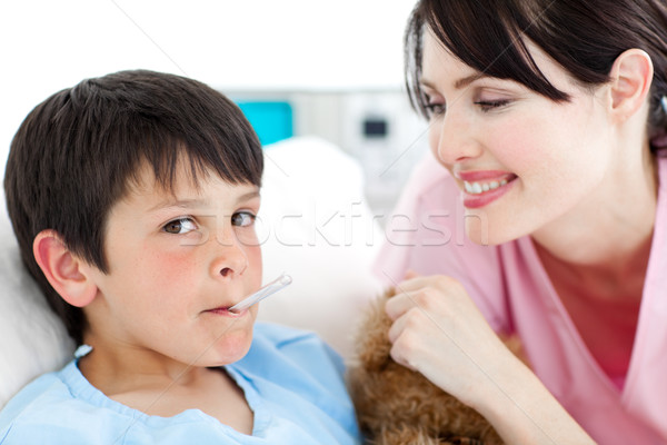 Stock photo: Charming nurse taking little boy's temperature 