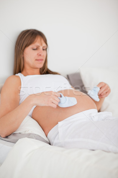 Bastante mulher grávida jogar pequeno meias cama Foto stock © wavebreak_media