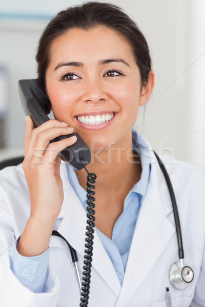 Gyönyörű női orvos telefon pózol iroda Stock fotó © wavebreak_media