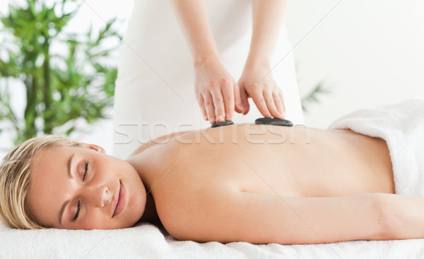 Blonde relaxed woman experiencing a stone therapy with closed eyes in a wellness center Stock photo © wavebreak_media