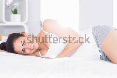 Stock photo: Close up of a smiling woman looking into the camera in her bedroom