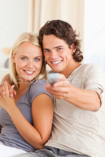 Stock photo: Portrait of a cute couple watching TV in their living room