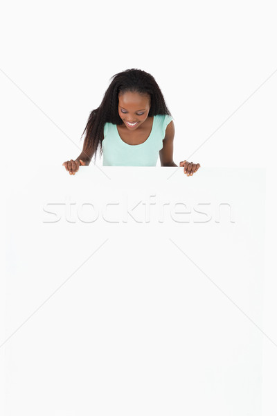 Smiling woman looking at placeholder in her hands on white background Stock photo © wavebreak_media