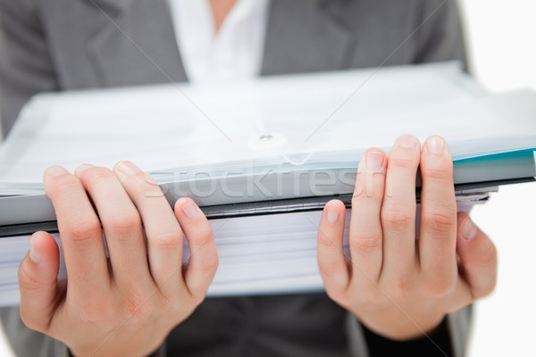 Stock photo: Pile of paperwork being held by female hands against a white background