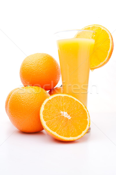 Heap of oranges near a glass of orange juice against white background Stock photo © wavebreak_media