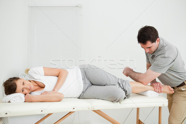 Doctor manipulating the leg of his patient while using his elbow in a room Stock photo © wavebreak_media