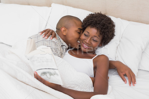 Stock photo: Happy couple lying in bed cuddling