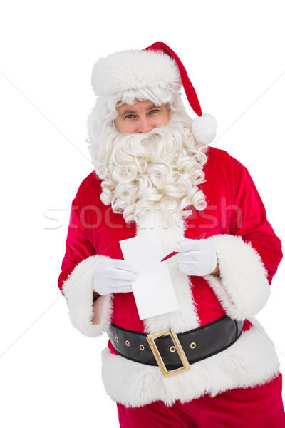 Happy santa holding paper and pen Stock photo © wavebreak_media