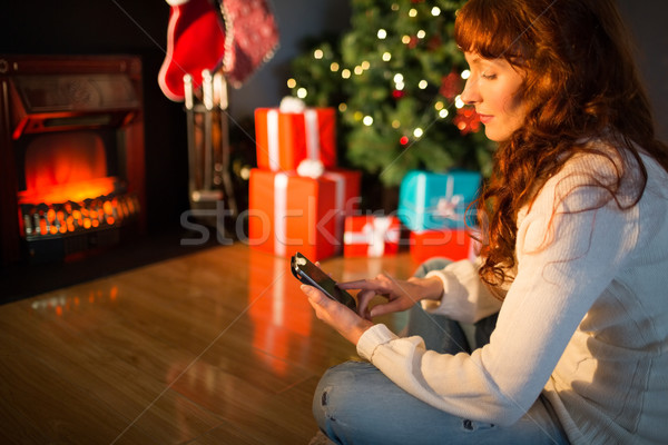 Smiling redhead using smartphone at christmas Stock photo © wavebreak_media