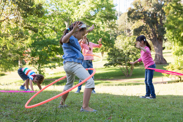 Little friends playing with hula hoops in park Stock photo © wavebreak_media
