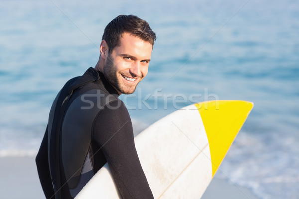 Man in wetsuit with a surfboard on a sunny day Stock photo © wavebreak_media
