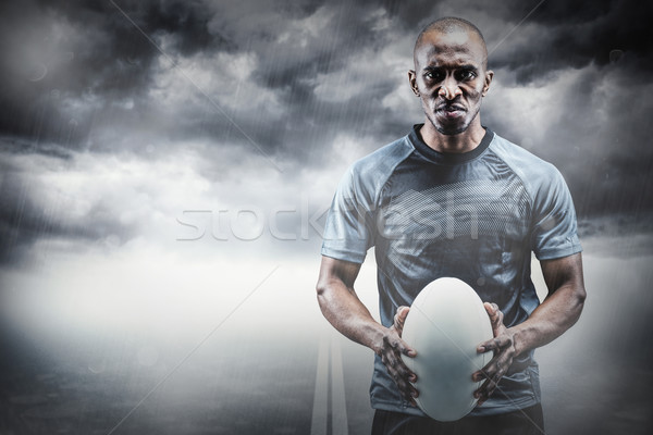 Composite image of portrait of serious athlete holding rugby bal Stock photo © wavebreak_media