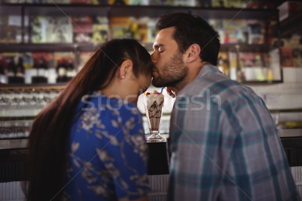 Affectionate man kissing woman at counter Stock photo © wavebreak_media