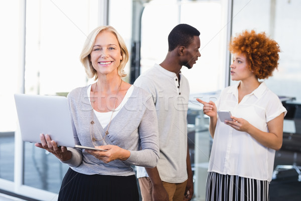 Portrait of mature businesswoman with colleagues in background Stock photo © wavebreak_media