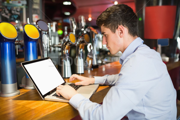 Człowiek za pomocą laptopa bar Licznik widok z boku technologii Zdjęcia stock © wavebreak_media