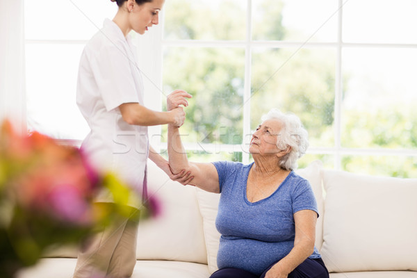 Physiotherapist taking care of sick elderly patient Stock photo © wavebreak_media