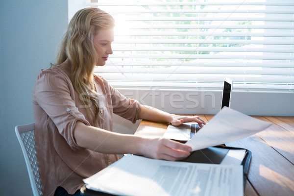 Mujer mirando proyecto de ley usando la computadora portátil casa ordenador Foto stock © wavebreak_media