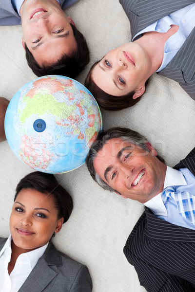 Business team lying on the floor around a terrestrial globe Stock photo © wavebreak_media