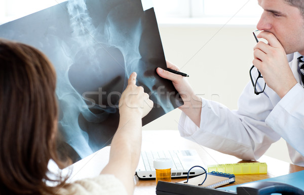 Attractive doctor analyzing an x-ray with a female patient Stock photo © wavebreak_media