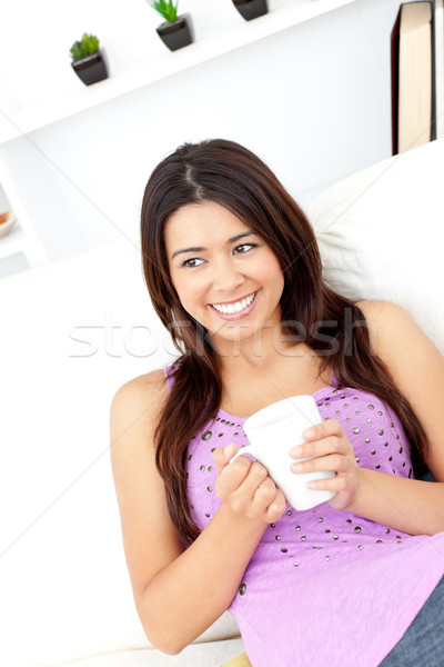 Relaxed woman holding a cup of coffee sitting on the sofa at home Stock photo © wavebreak_media
