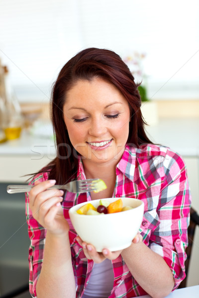 Joyeux femme manger salade de fruits déjeuner cuisine [[stock_photo]] © wavebreak_media