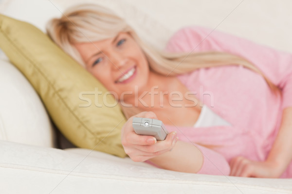 Gorgeous blonde female posing while lying on a sofa in the living room Stock photo © wavebreak_media