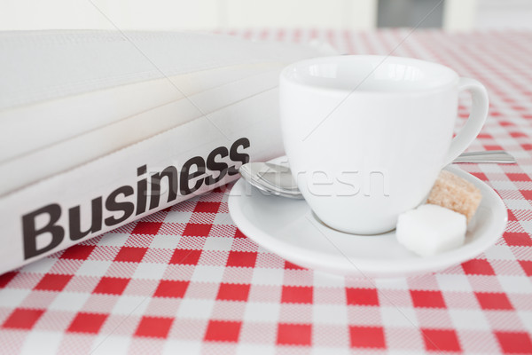 A cup of tea and a newspaper on a tablecloth in a kitchen Stock photo © wavebreak_media