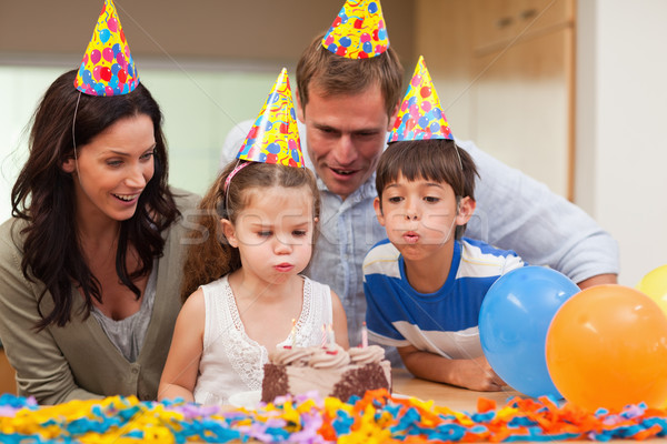 Young boy helping his little sister to blow out the candles on her birthday cake Stock photo © wavebreak_media