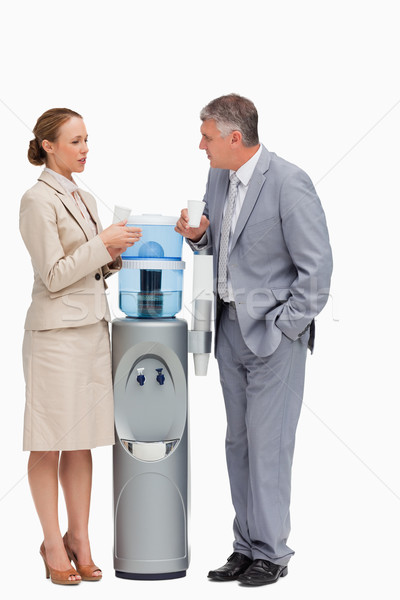 People in suit talking next to the water dispenser against white background Stock photo © wavebreak_media