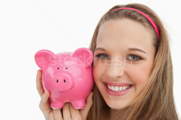 Close-up of a young woman holding a piggy-bank against white background Stock photo © wavebreak_media