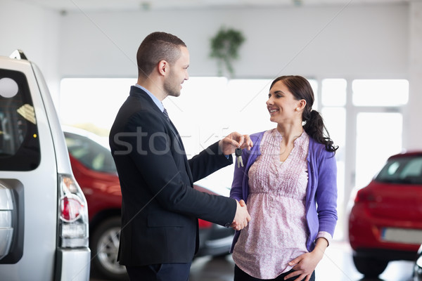 Femeie strangere de mana vanzator cheile de la masina maşină magazin Imagine de stoc © wavebreak_media