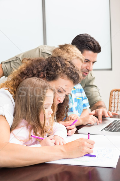 Attractive parents colouring and using laptop with their childre Stock photo © wavebreak_media