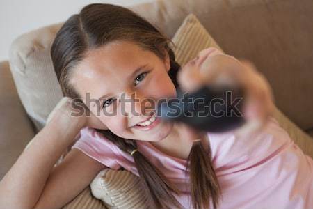 Portrait of a girl changing channels in living room Stock photo © wavebreak_media