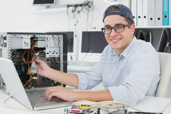 Computer engineer working on broken console with laptop Stock photo © wavebreak_media