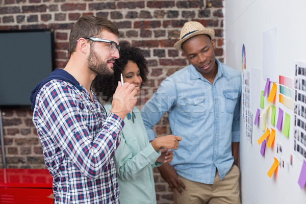 Team looking at sticky notes on wall Stock photo © wavebreak_media