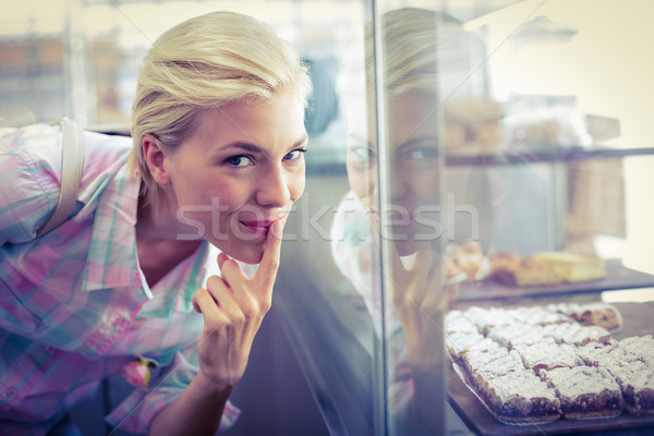 Hesitating pretty woman looking at cup cakes  Stock photo © wavebreak_media