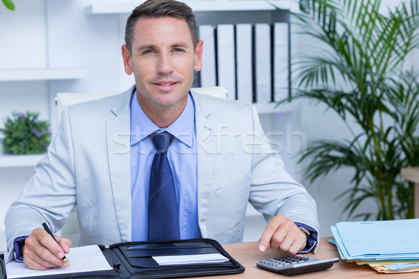 Professional businessman writing on his notebook Stock photo © wavebreak_media