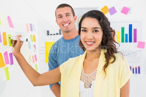 Portrait of smiling coworkers writing on sticky notes Stock photo © wavebreak_media